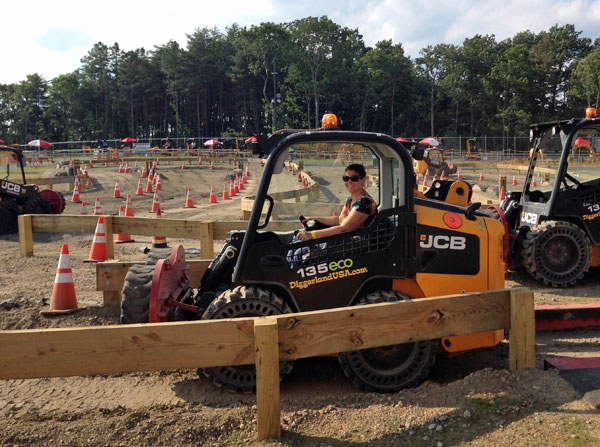 Shannon driving a skid steer.