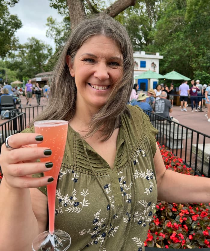 Woman smiling and holding a mimosa.