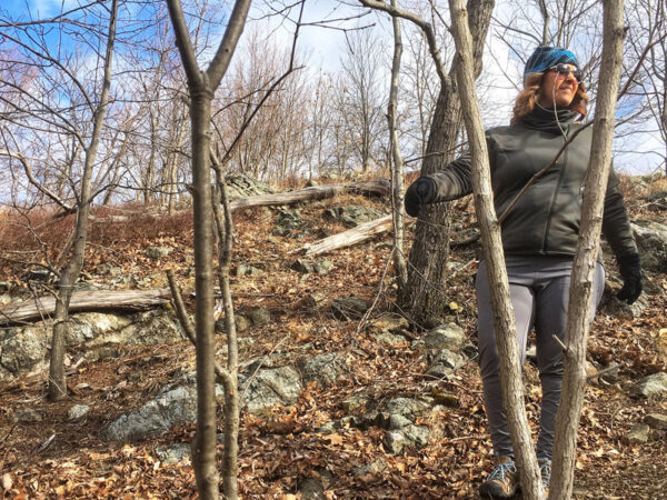 Shannon walking on a trail in the woods.